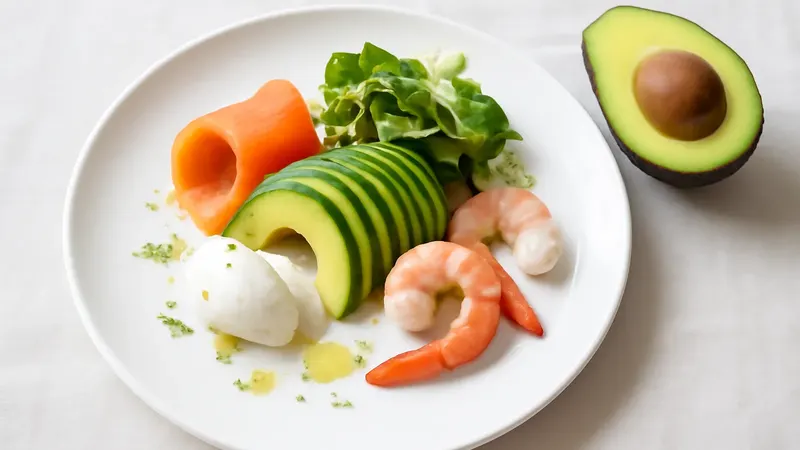 Assiette blanche avec saumon fumé en vague, crevettes roses, éventail d'avocat, jeunes pousses et quenelle de crème au raifort